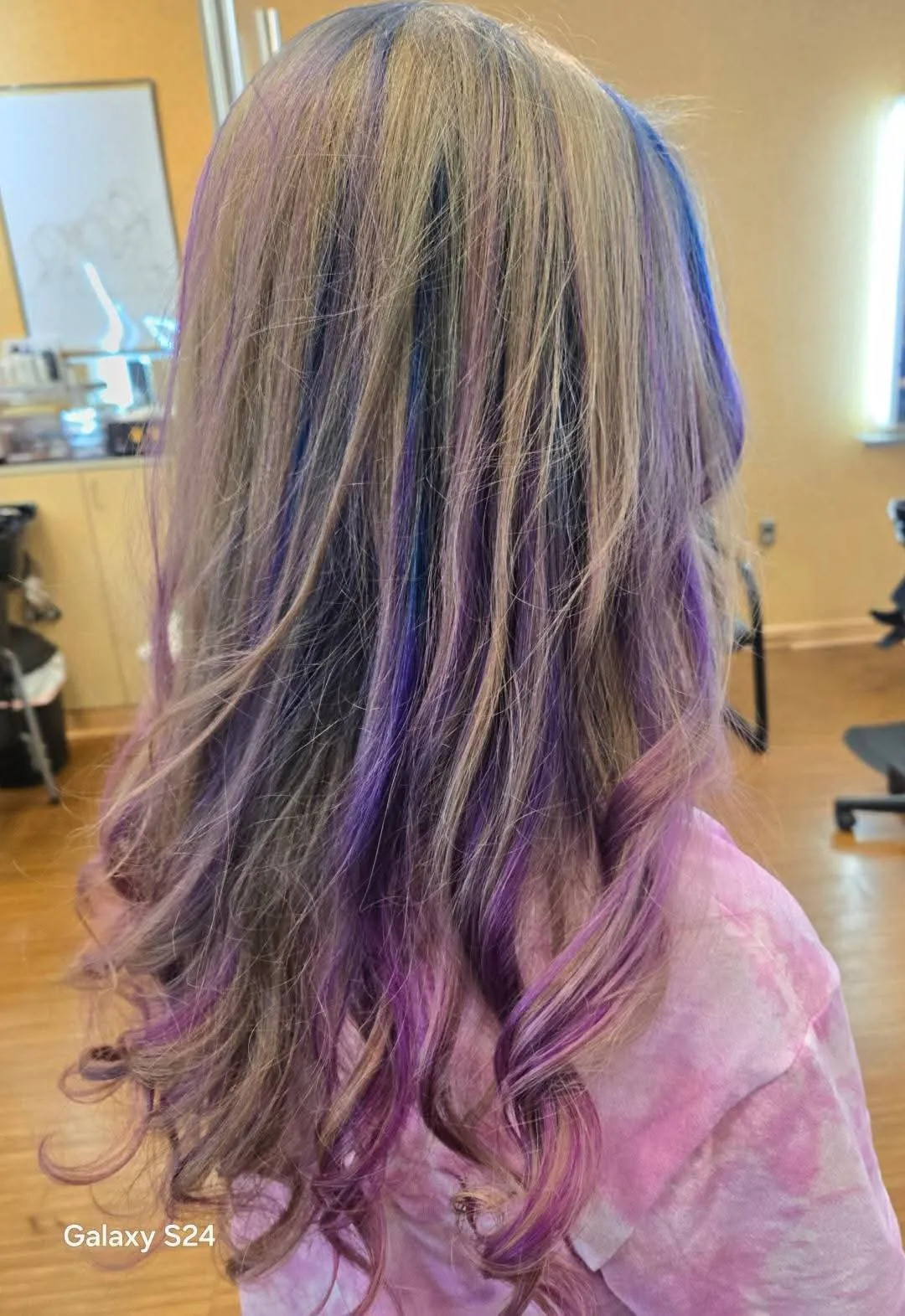 Purple and blue peekaboo highlights tucked beneath blonde