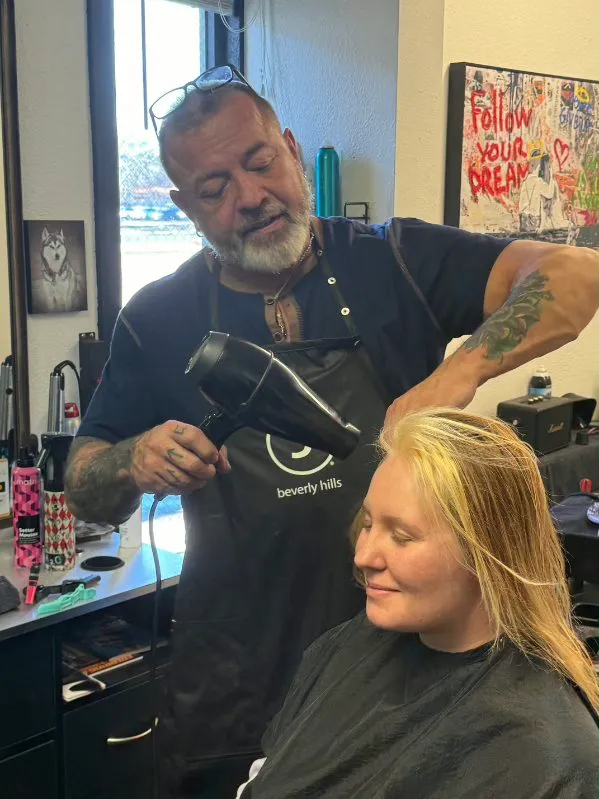 Rob Maggart styling a client's hair in his studio